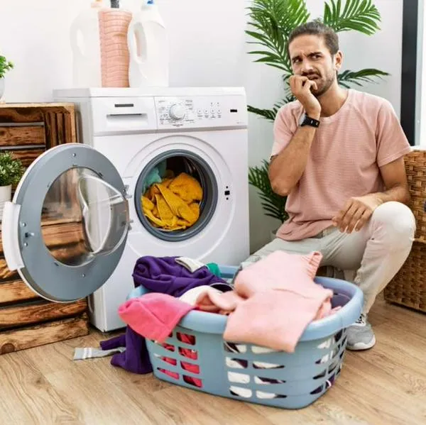 Foto de hombre con lavadora, en nota de cómo gastar menos con la lavadora para aprovechar el agua y ahorrar en el recibo