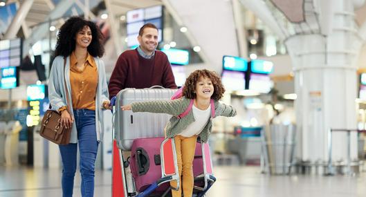 Niño con papás en el aeropuerto, en nota sobre qué necesitan los menores para ir a Estados Unidos