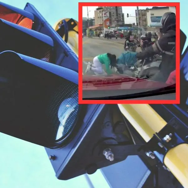 Mujer con coche cruzó corriendo semáforo en Bogotá, cayó y casi causa accidente