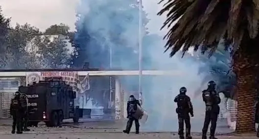 Policía en Bogotá casi es quemado por bomba durante protestas en la Universidad Nacional. Le cayó en su pierna y afectó el pantalón. 