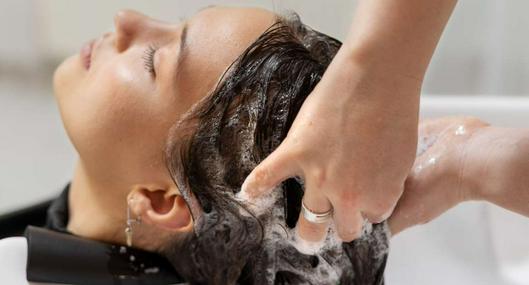 Foto mujer bañándose, en nota de cómo se escribe el plural de champú o shampoo y cuál es la forma bien en español