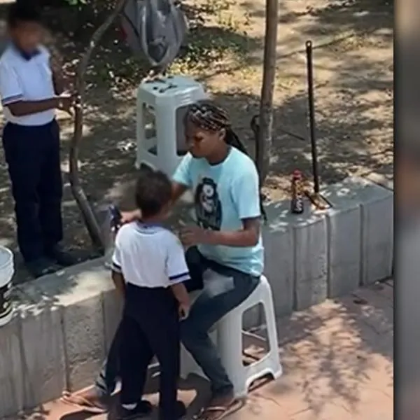 ¡Una guerrera! Mujer trabaja limpiando vidrios en un semáforo y fue grabada alistando sus hijos para el colegio