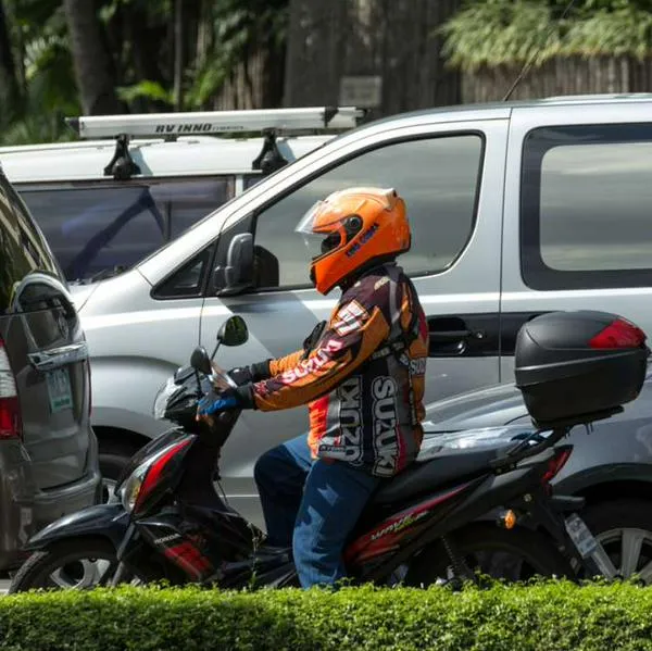 Foto de motociclista, en nota de cuál es la multa por meter celular al casco para hablar, según norma en Colombia
