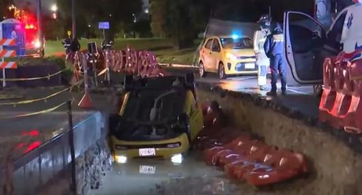 Taxista en Bogotá casi muere ahogado por gigantesco hueco al que cayó cuando manejaba su vehículo. El vehículo quedó en una excavación. 