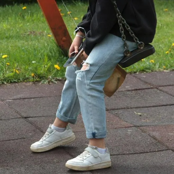 Imagen de referencia de persona joven en un columpio.
