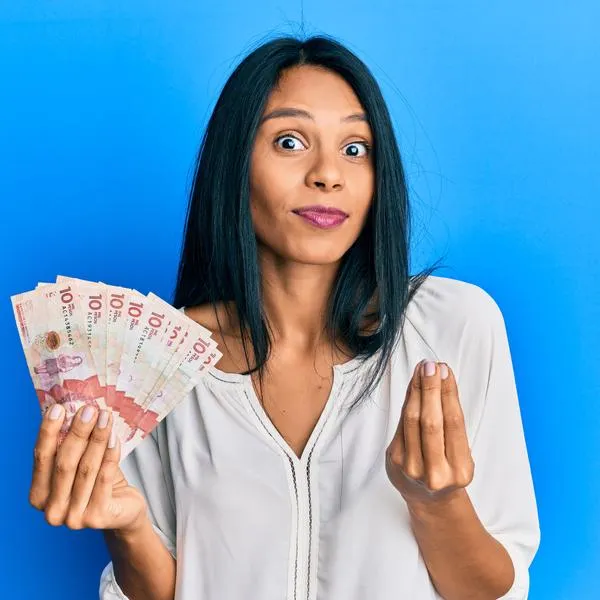 Persona con dinero colombiano en fondo azul.