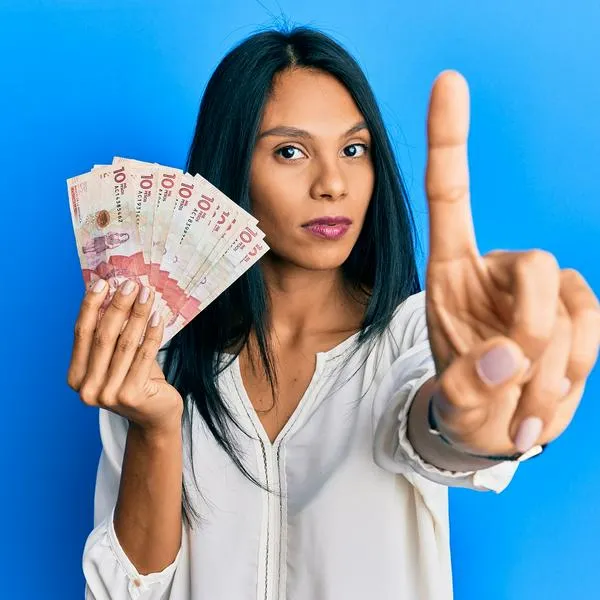 Mujer con dinero colombiano, en nota sobre que cambiarían subsidios del país