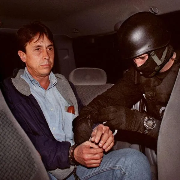 (FILES): This 08 September 2001 file photo by the US Drug Enforcement Administration (DEA) shows a US agent (R) transferring alleged Colombian drug lord Fabio Ochoa (L) to a waiting vehicle upon his arrival at Miami International Airport in Miami, Florida.  A Miami court 26 August 2003  sentenced Colombian Ochoa to 30 years in prison after a jury in May found the former Medellin drug cartel kingpin guilty of involvement in a major cocaine smuggling ring.   AFP PHOTO/DEA/FILES (Photo by DEA FILES / AFP)