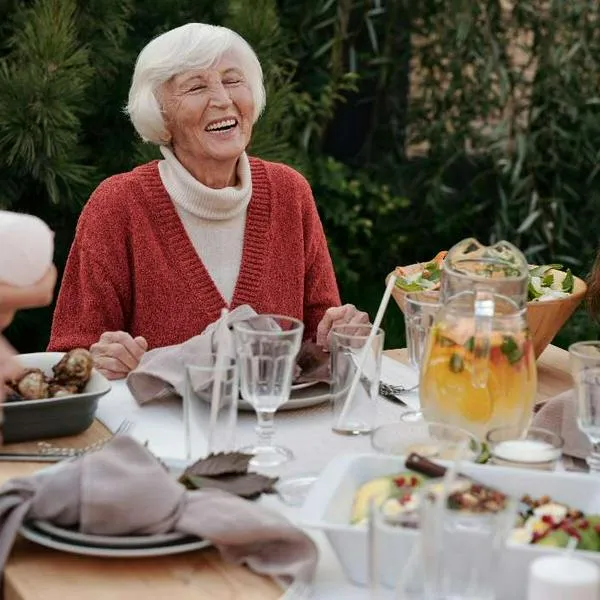 Foto de familia cenando, en nota de qué significa sentarse siempre en el mismo lugar de la mesa, según la psicología