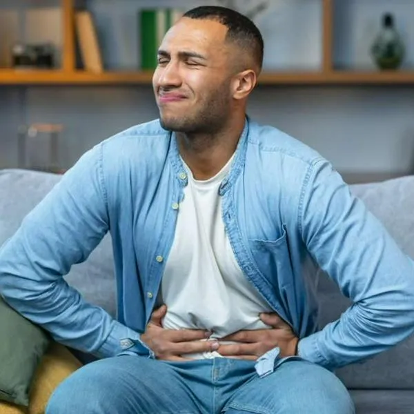 Foto de dolor de estómago, en nota de cómo evitar inflamación de barriga con comidas en reuniones, con pasos simples