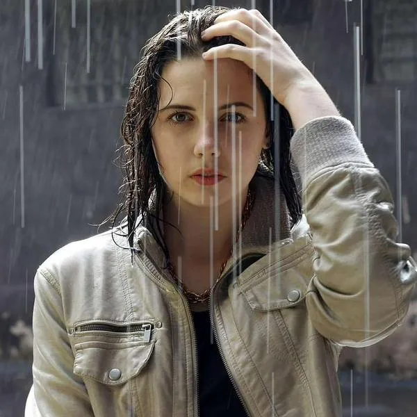 Foto de mujer en llovizna, en nota de qué es mejor entre correr o caminar bajo la lluvia: no pasa como podría pensarse