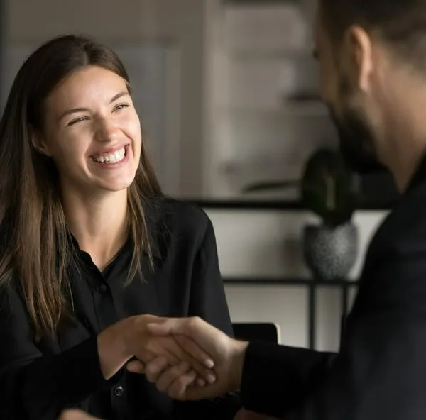 Mujer alegre en entrevista de trabajo, a propósito de cómo negociar un buen salario: consejos