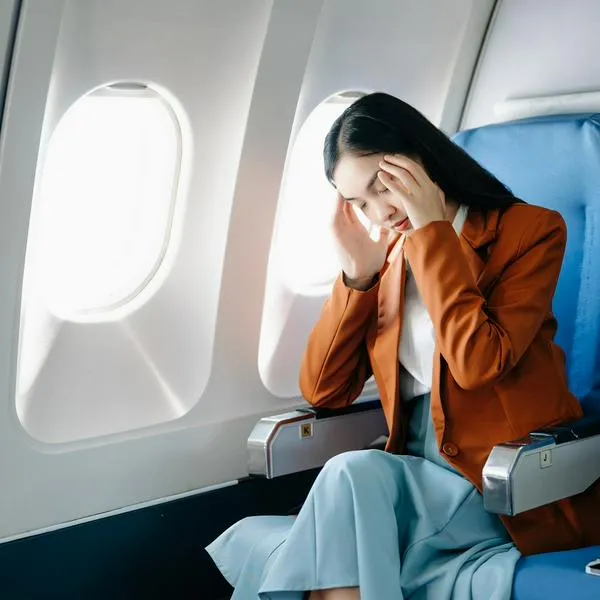 Mujer apoyando la cabeza en una ventada de avión, en nota sobre por qué es una mala práctica