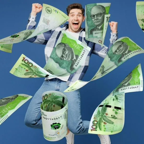 Persona celebrando con dinero de Colombia, en nota sobre que cayó la Lotería de Manizales