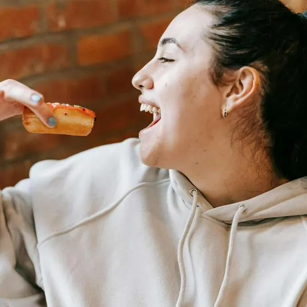 Foto de mujer comiendo, en nota de qué significa que una persona tenga hambre casi todo el tiempo, según psicología