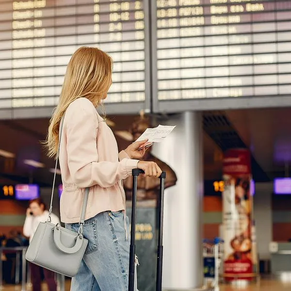 Mujer en aeropuerto, en nota sobre cuáles son los más puntuales del mundo, uno está en Sudamérica