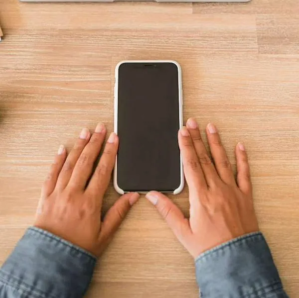 Foto de celular en mesa, en nota de qué significa que una persona ponga celular boca abajo, según psicología
