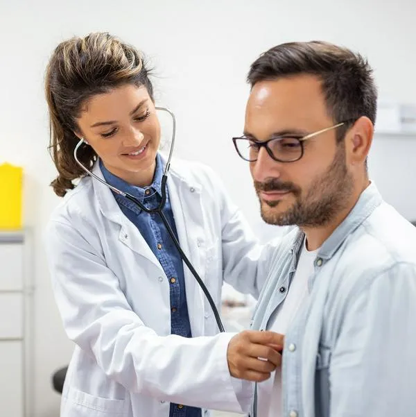 Médica revisando a un hombre, en nota sobre exámenes médicos imprescindibles para empezar una vida 'fit'