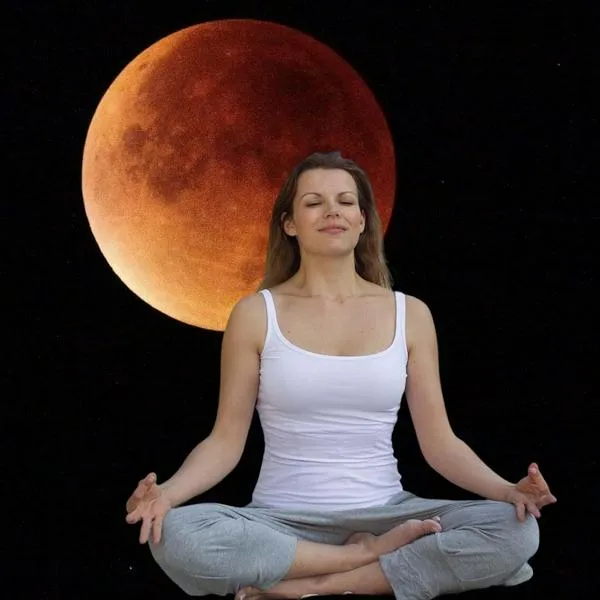 Eclipse lunar y persona meditando en rituales para hacer durante el eclipse de marzo