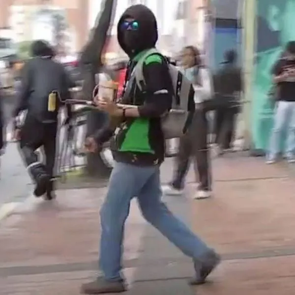 Momento en el que un encapuchado intimida a un periodista de Citytv durante las marchas en Bogotá del 18 de marzo