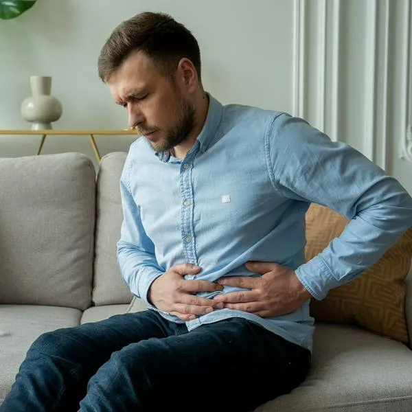 Hombre con dolor de estómago, en nota sobre síntomas del cáncer gástrico