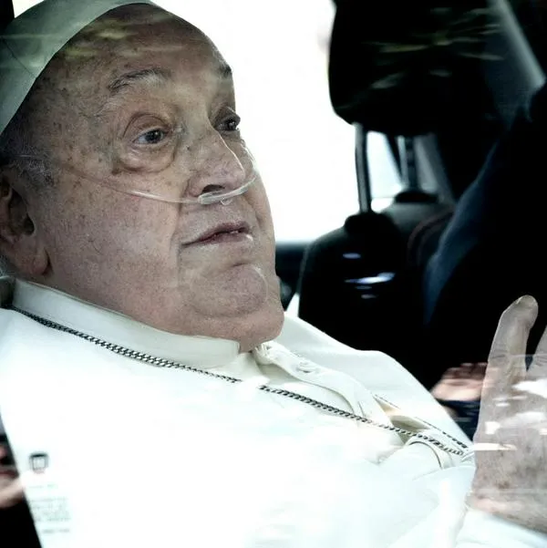 Pope Francis waves as he leaves by car the Gemelli hospital after a five weeks hospitalization for pneumonia, in Rome on March 23, 2025. Pope Francis is to leave hospital todayand return to his residence in the Vatican, where he is to spend "at least two months" recovering, one of his doctors announced during a press conference on March 22, 2025. (Photo by Tiziana FABI / AFP)