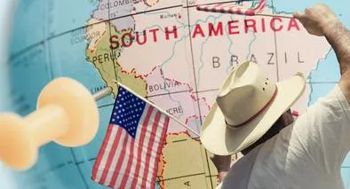 Mapa de Sudamérica y hombre con banderas de Estados Unidos, en nota sobre que Brasil empezó a exigir visa a los estadounidenses
