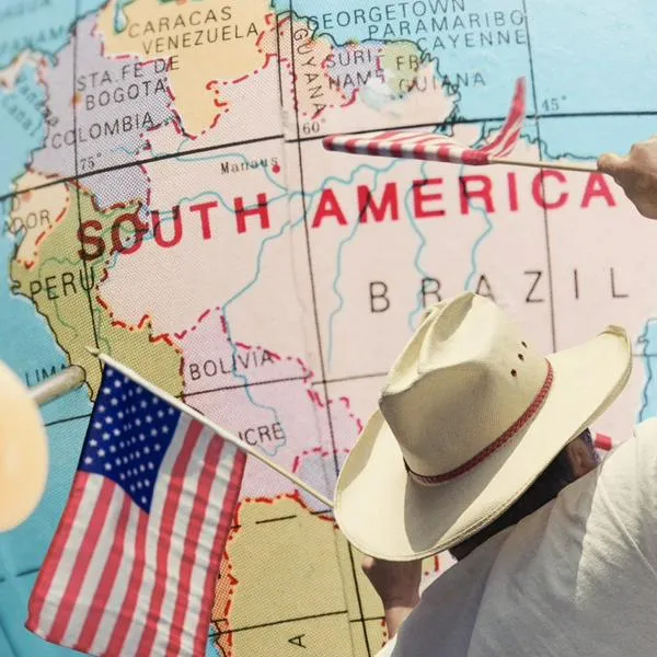 Mapa de Sudamérica y hombre con banderas de Estados Unidos, en nota sobre que Brasil empezó a exigir visa a los estadounidenses