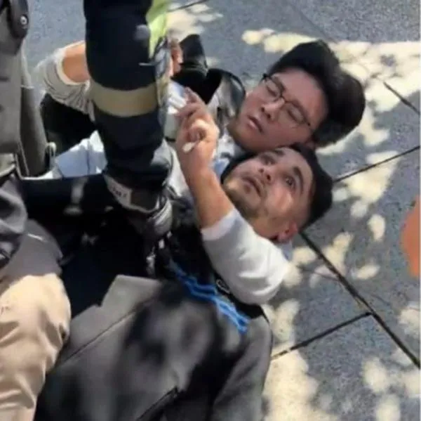 Momento en el que un fotógrafo somete a un ladrón con una llave de artes marciales