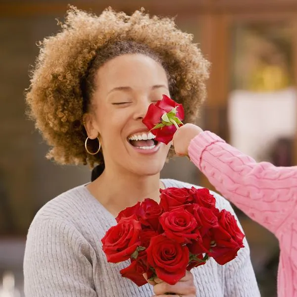 Mujer recibiendo flores de una niña, en nota sobre ciudad de Colombia que tiene un Día de la Madre distinto