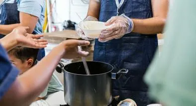 The unrecognizeable people serve food to those in need at the food drive.