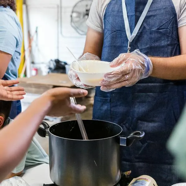 The unrecognizeable people serve food to those in need at the food drive.