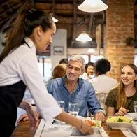 Foto de meseros, en nota de qué significa que alguien ayude a meseros a recoger la mesa, según la psicología