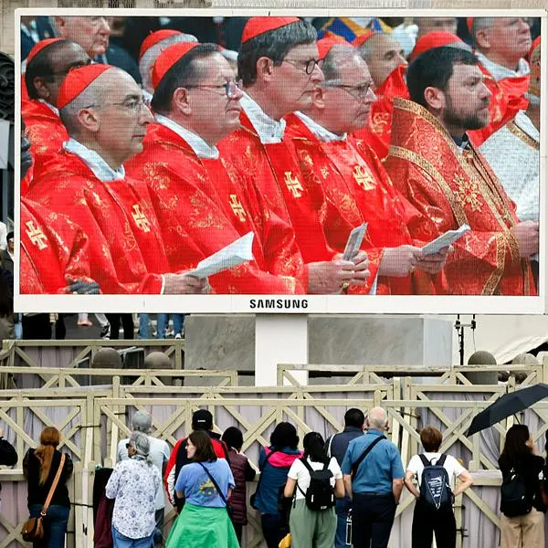 VATICAN CITY, VATICAN - MAY 07: Cardinals are shows on screen as people gather in St. Peter's Square and watch the Mass for the Election of the New Pope on screens before the start of the conclave on May 07, 2025 in Vatican City, Vatican. Cardinals of the Catholic Church have descended on Vatican City to commence the papal conclave, the secretive voting process held in the Sistine Chapel that requires a two-thirds majority to elect the new leader of the Catholic Church. The election follows the death of Pope Francis on April 21 at the age of 88. (Photo by Mario Tama/Getty Images)