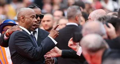 US actor Denzel Washington argues with a photographer next to US singer and actor ASAP Rocky as they arrive for the screening of the film "Highest 2 Lowest" at the 78th edition of the Cannes Film Festival in Cannes, southern France, on May 19, 2025. (Photo by Sameer AL-DOUMY / AFP)