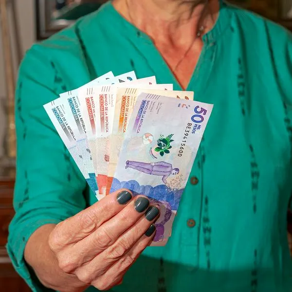 Adulta mayor sosteniendo billetes de Colombia, en nota sobre quiénes recibirán plata en Medellín 