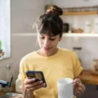 Foto de persona con celular, en nota de qué significa que una persona no hable en grupos de WhatsApp, según psicología