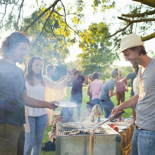 Personas haciendo asado en un parque, en nota sobre cómo reservar para hacer uno en Bogotá
