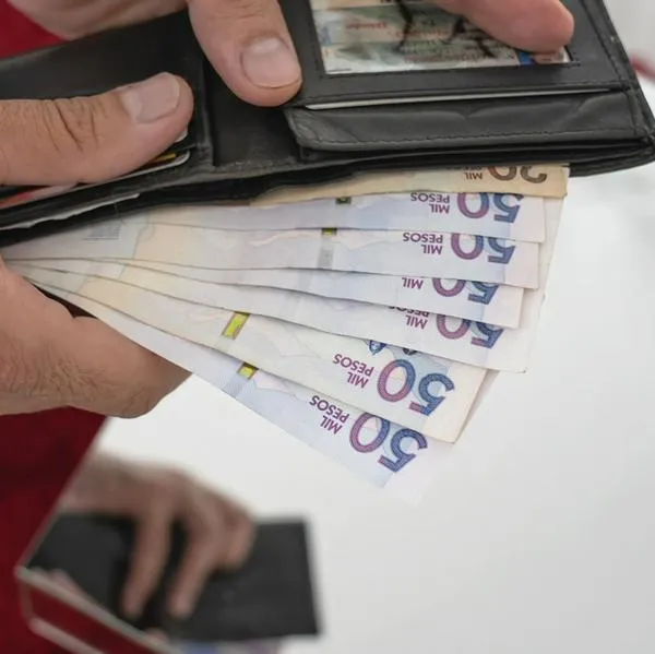50 thousands pesos bills from Colombia coming out of a man´s  wallet