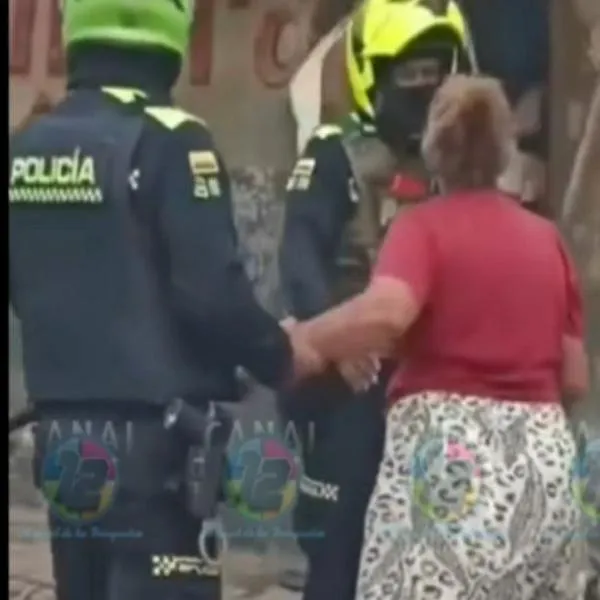 Momento en el que la Policía saca a una joven a la que una mujer mayor quería golpear porque la halló con su esposo