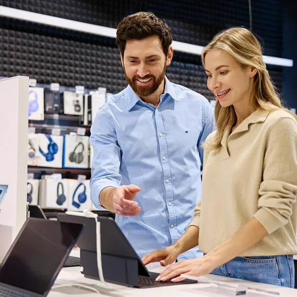 Personas en supermercado mirando computadores, en nota sobre descuentos en Alkomprar