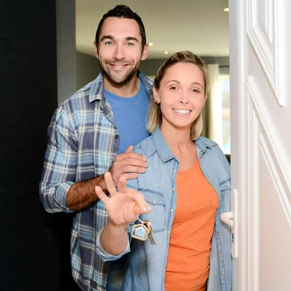 Foto de pareja con llaves de vivienda, en nota de qué es mejor entre arrendar una vivienda o ponerla para Airbnb en Colombia ahora