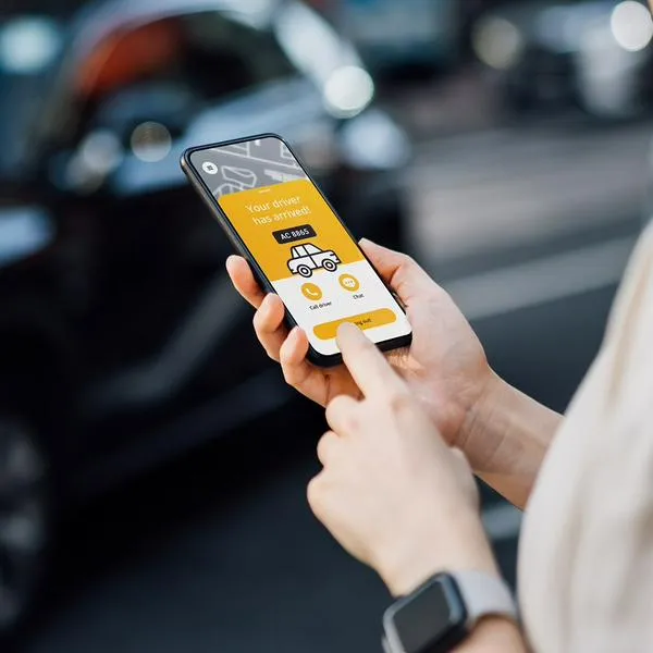 Mujer usando aplicación para pedir taxi, en nota sobre que plataforma colombiana llegó a México