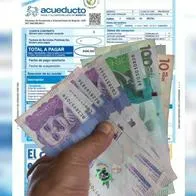 Factura del Acueducto y billetes de Colombia, en nota sobre bancos en los que ya no se puede pagar 
