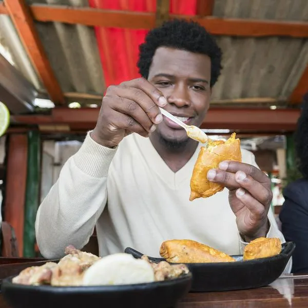 Hombre comiendo empanada