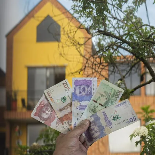 Persona sosteniendo dinero de Colombia, en nota sobre subsidio de 25 millones de pesos que darán a cientos de paisas