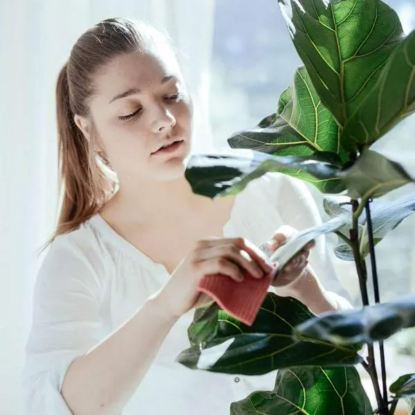 Foto mujer con plantas, en nota de qué significa que persona hable con plantas según psicología, y si es enfermedad