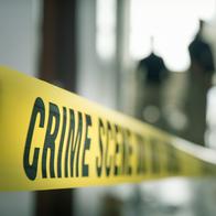 crime scene tape with blurred forensic law enforcement background in cinematic tone and copy space