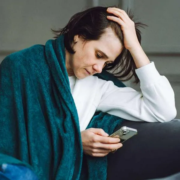 Foto de mujer con celular, en nota de qué significa doomscrolling y por qué es peligroso para cerebro, ojo con celular
