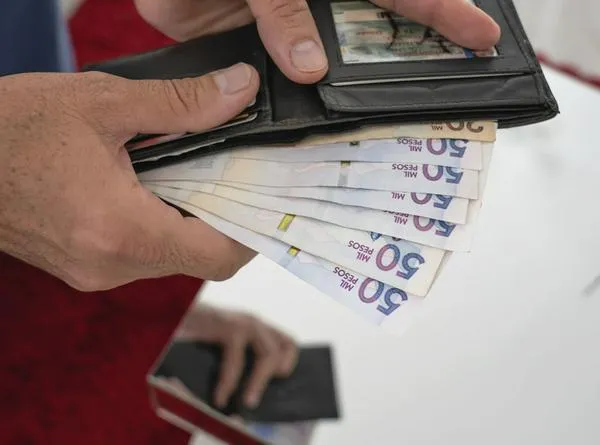 50 thousands pesos bills from Colombia coming out of a man´s  wallet